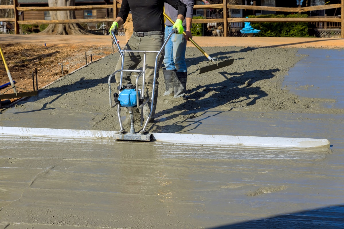 contractor smoothing concrete with machine