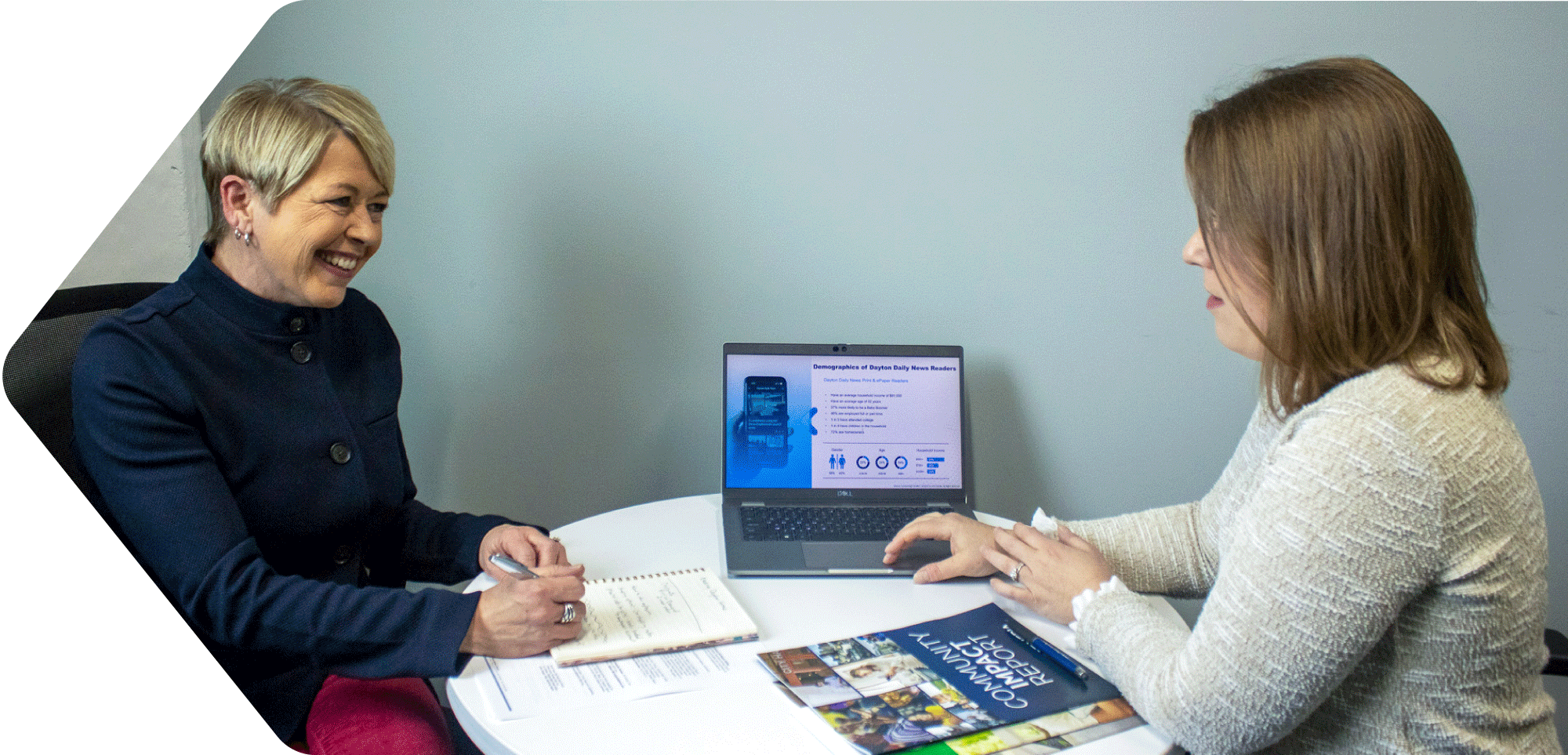 Two women reviewing marketing materials in office
