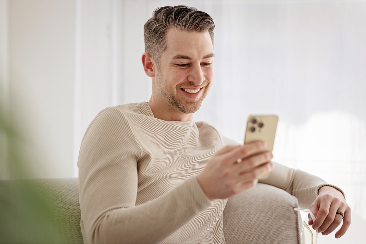 Man smiling while looking at phone
