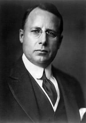 James M. Cox in suit with clear glasses on